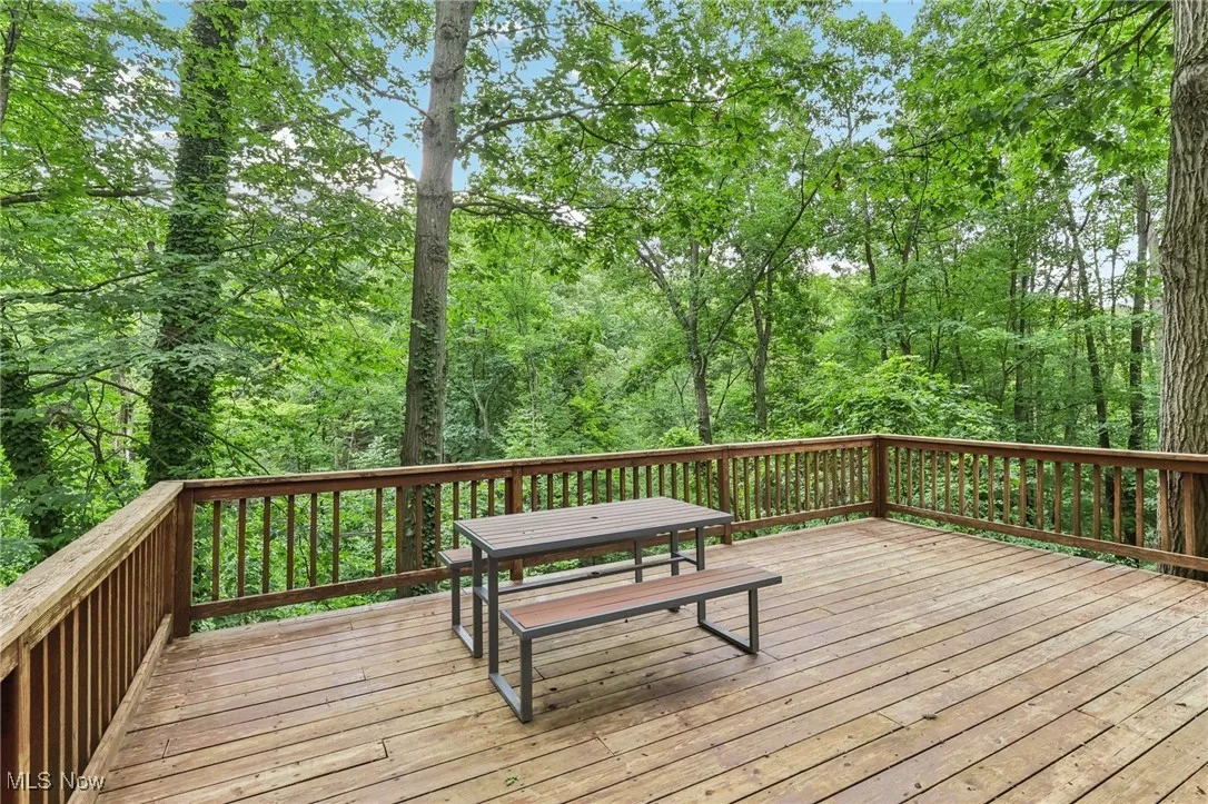 Wooden terrace featuring a wooded view