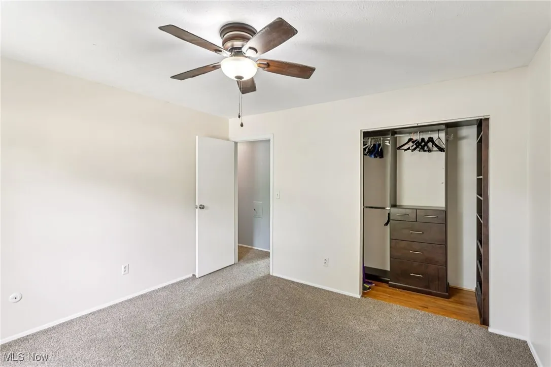 Unfurnished bedroom with carpet flooring, a closet, and a ceiling fan