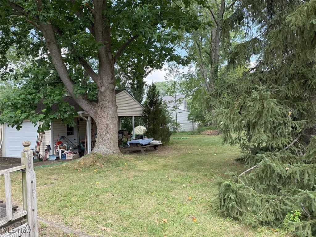 View of grassy yard with a garage
