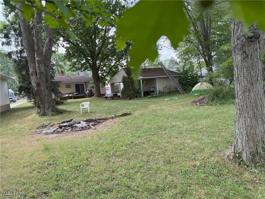 View of grassy yard with a fire pit