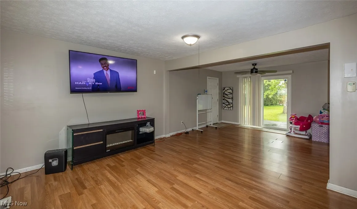 Living area with wood finished floors, a textured ceiling, and ceiling fan