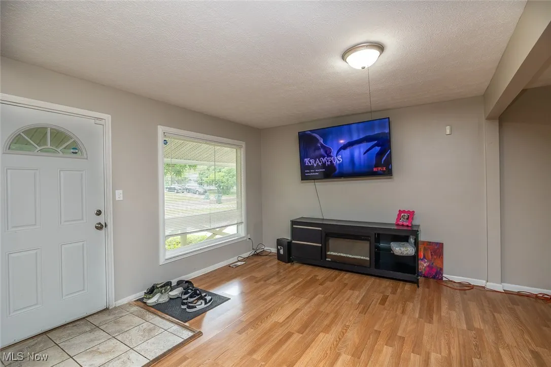 Entrance foyer with light wood-style floors and a textured ceiling