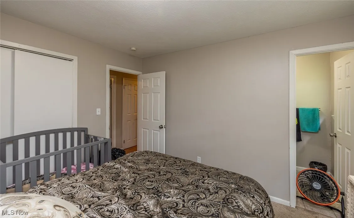 Carpeted bedroom featuring a closet and baseboards