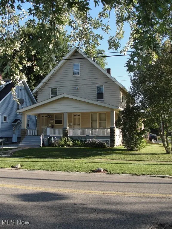 View of front of property with a porch and a front yard