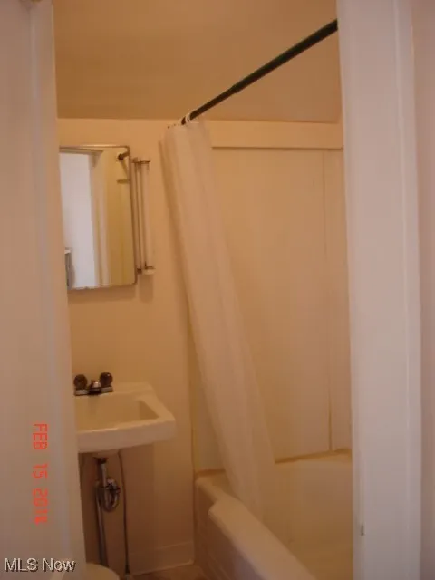 Bathroom featuring a sink and shower / bath combo