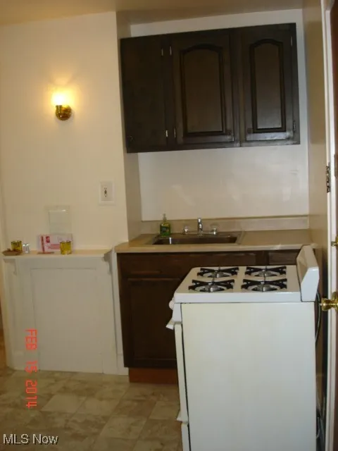 Kitchen featuring range, dark brown cabinets, and light countertops