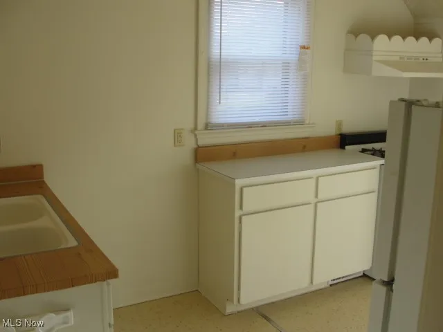 Kitchen with white cabinetry and light countertops