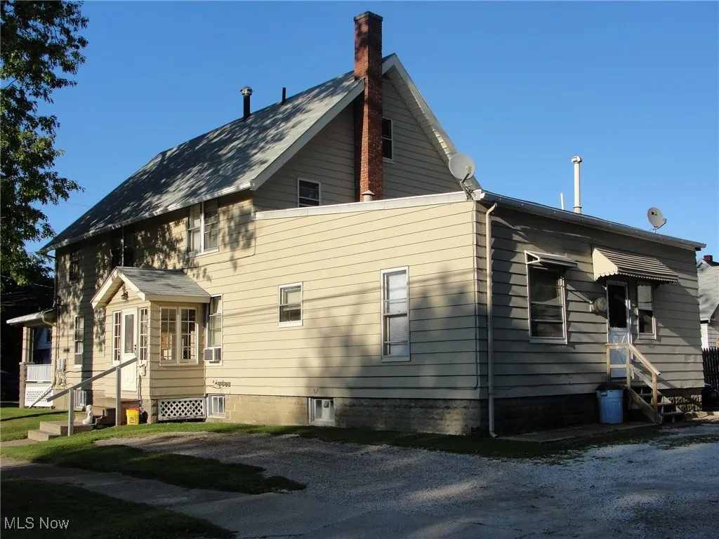 View of home's exterior featuring entry steps and a chimney
