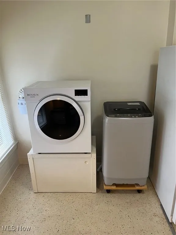 Laundry room with separate washer and dryer and baseboards