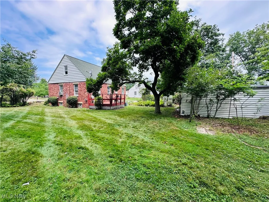 View of green lawn with a wooden deck