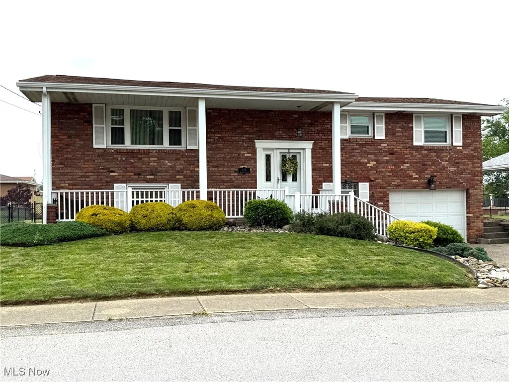 Front of home with concrete driveway, an attached garage, and a front yard