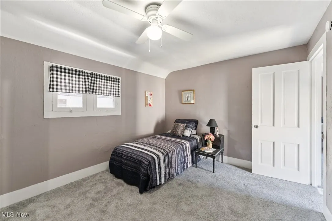 Carpeted bedroom with baseboards and ceiling fan