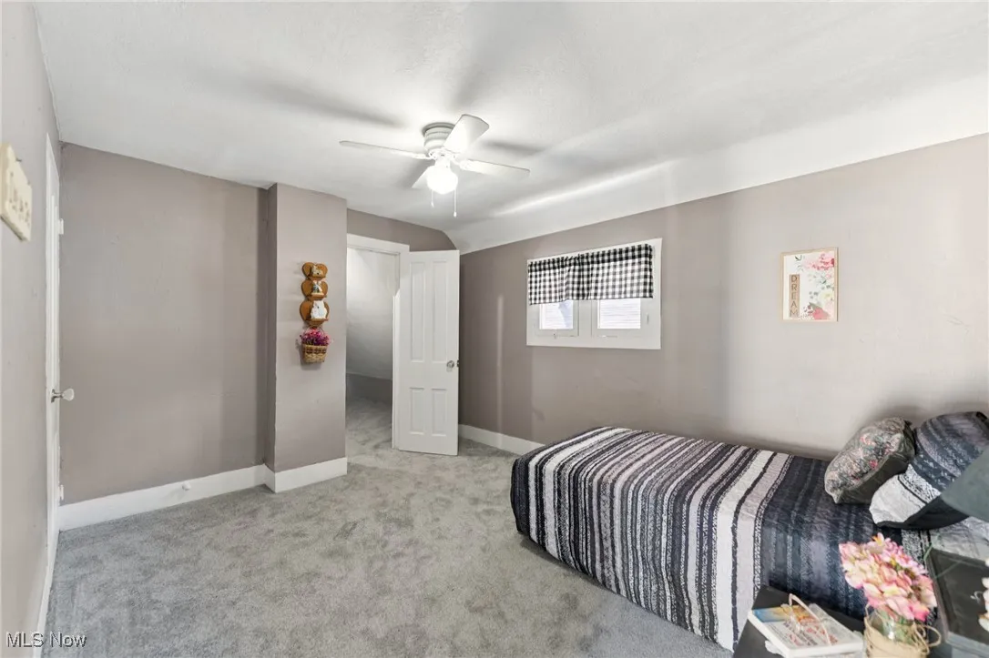 Carpeted bedroom featuring baseboards and ceiling fan