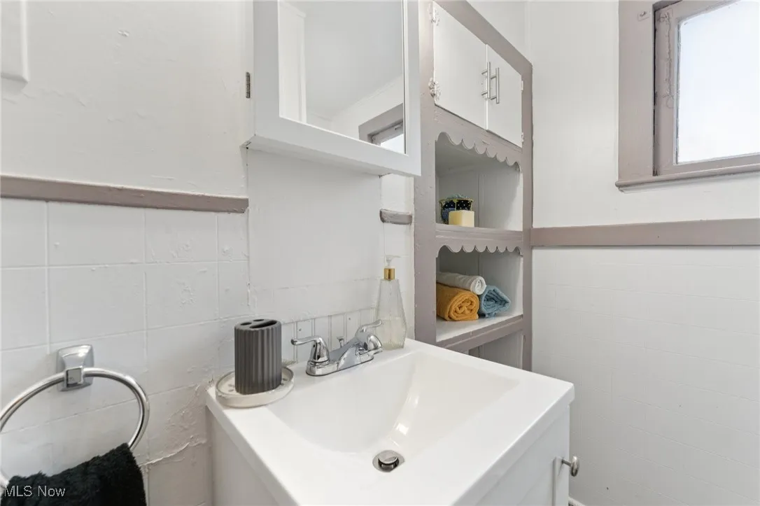 Bathroom featuring tile walls and a sink