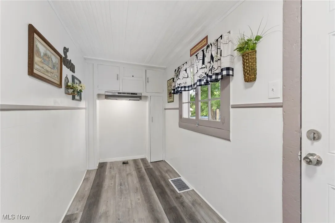 Corridor with wood finished floors and wooden ceiling