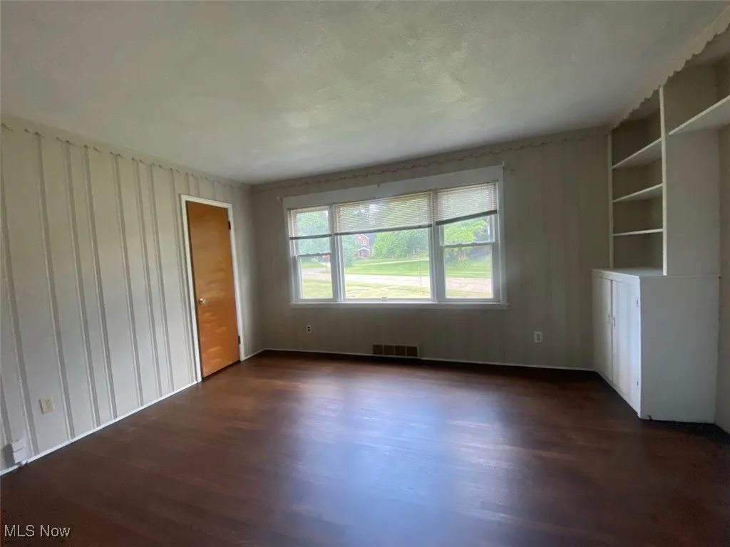 Unfurnished room with dark wood-style floors
