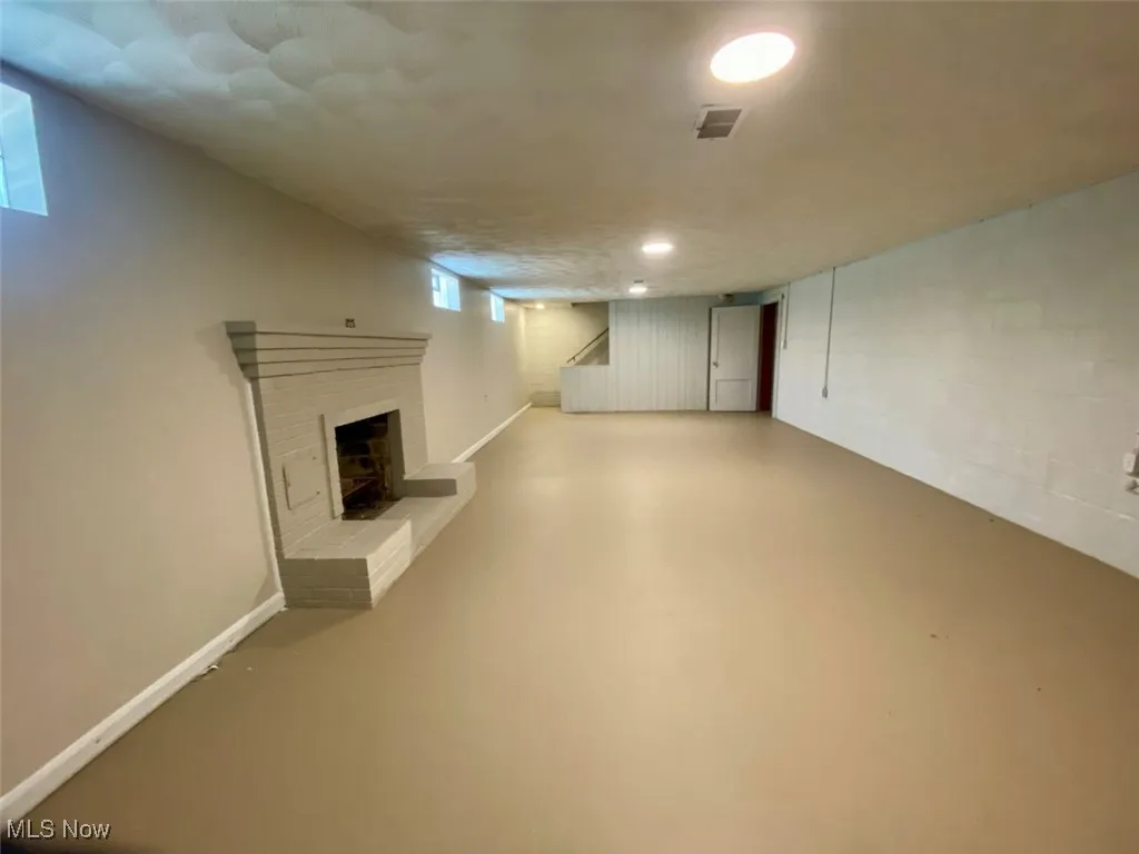 Below grade area with a brick fireplace and stairs