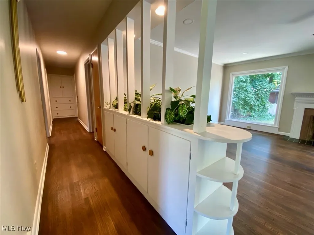 Hall featuring dark wood finished floors, crown molding, and recessed lighting