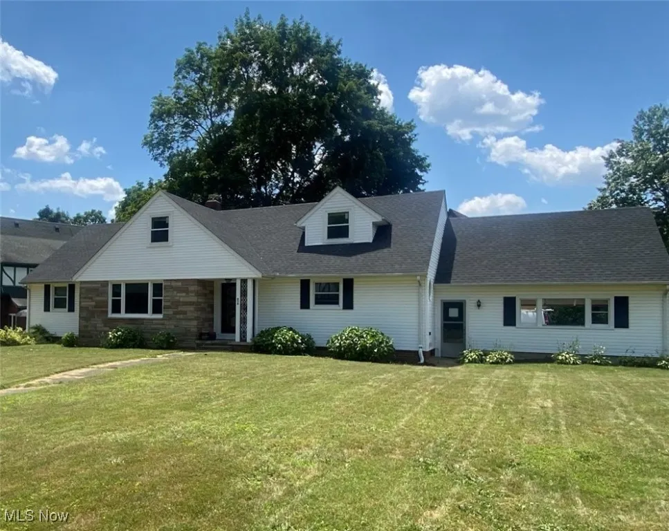 Cape cod house with a front lawn and a shingled roof