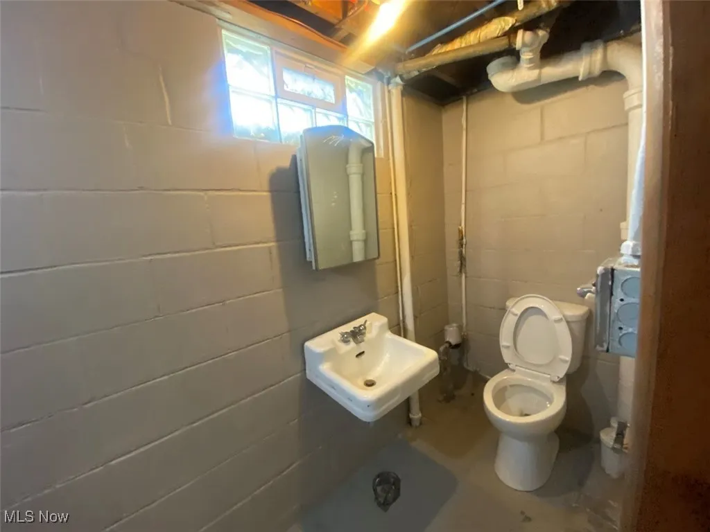 Bathroom with a sink and unfinished concrete flooring