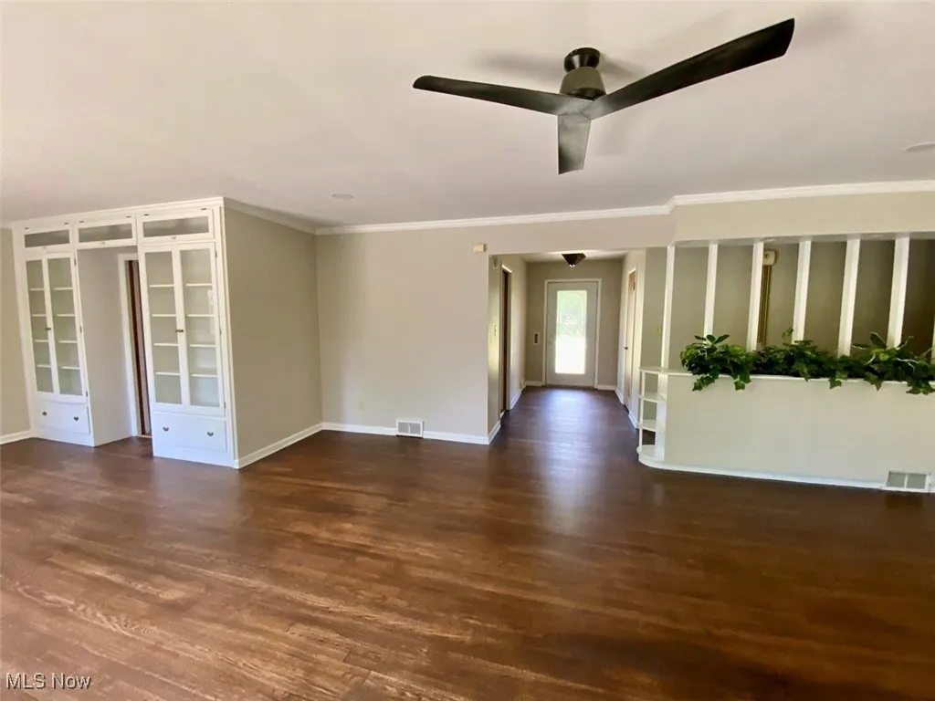 Spare room featuring ceiling fan, wood finished floors, and crown molding
