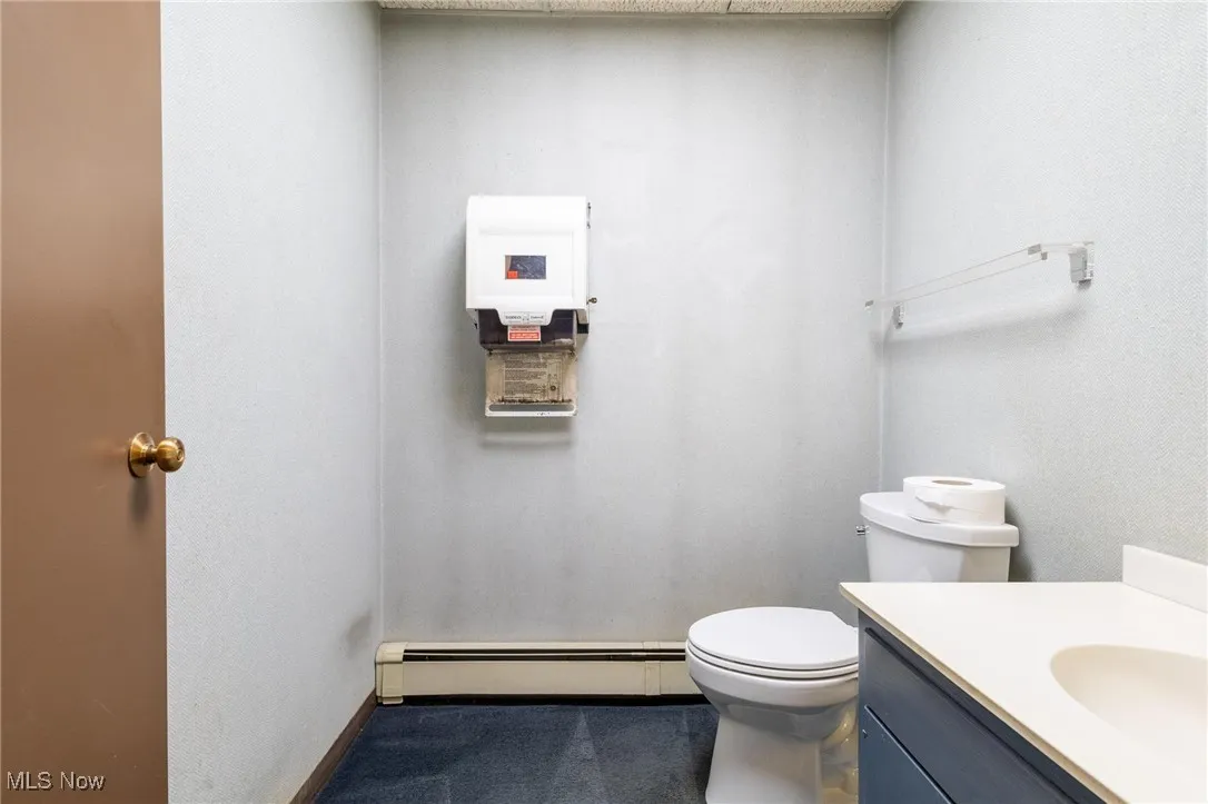 Half bathroom with a baseboard heating unit and vanity