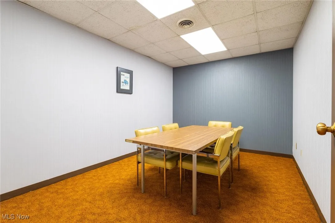 Dining space featuring carpet and a drop ceiling