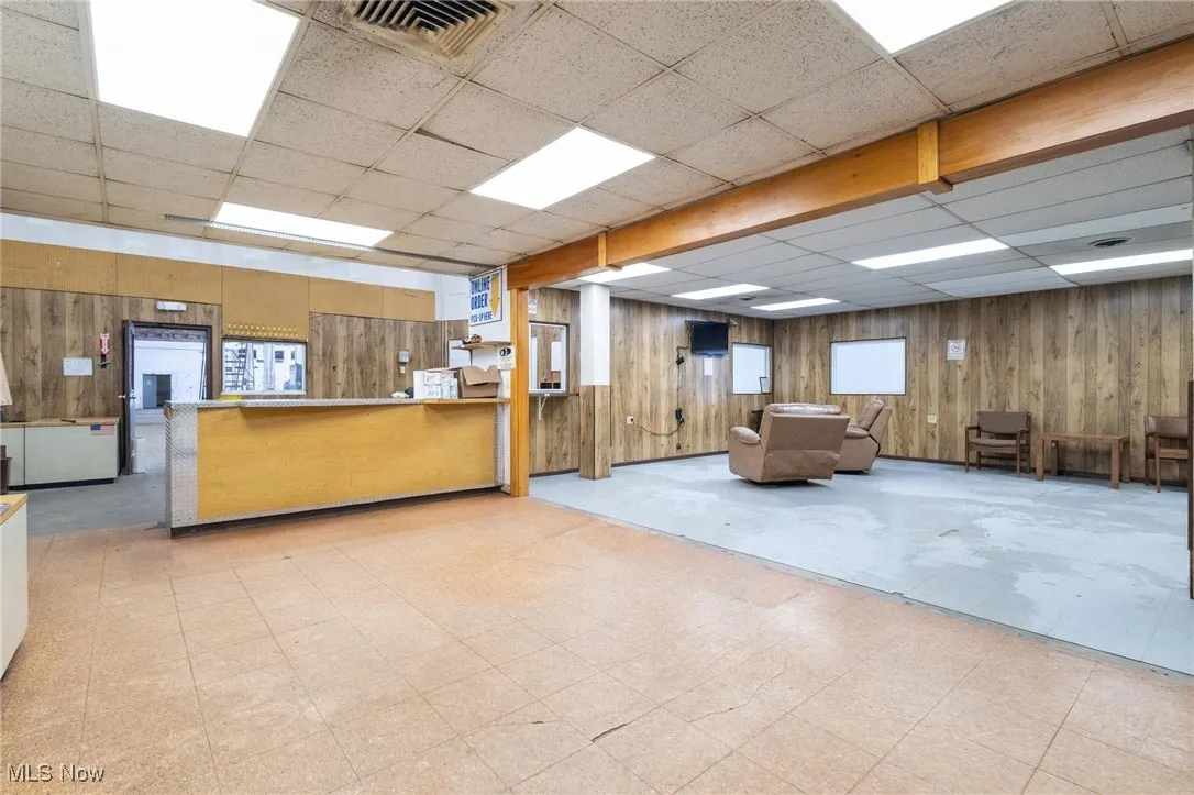 Welcome area featuring a paneled ceiling and wood walls