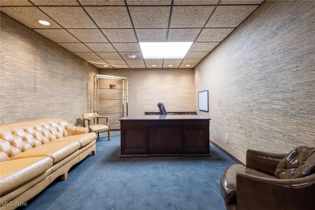 Carpeted office space featuring a paneled ceiling and recessed lighting
