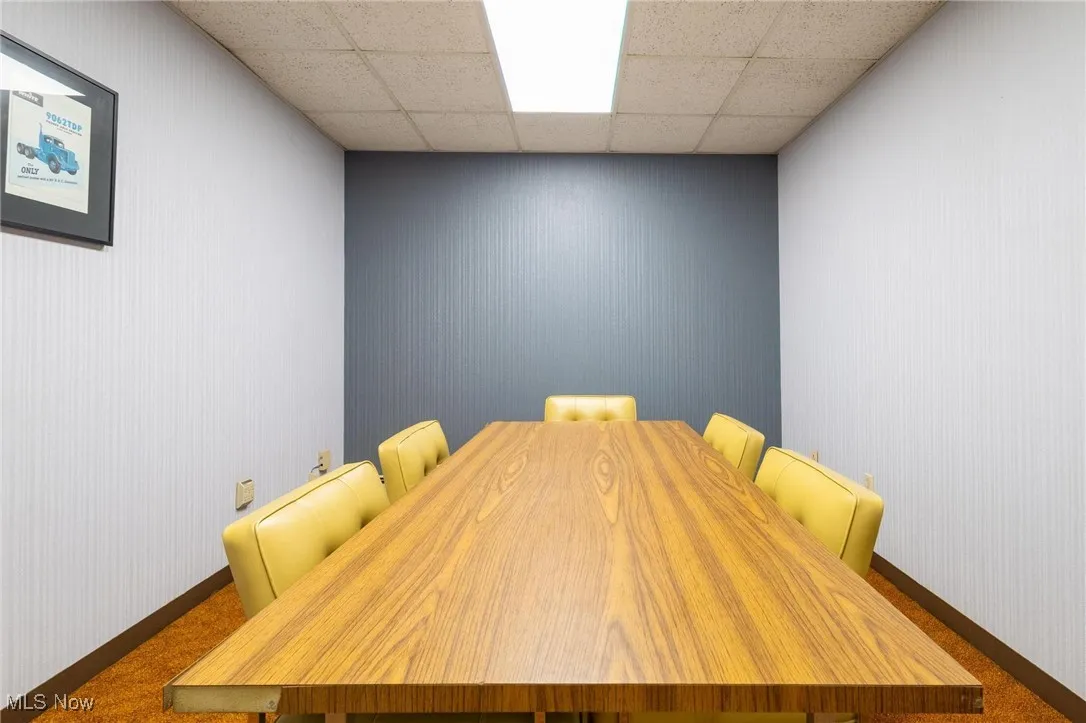 Dining area featuring carpet, wallpapered walls, and a paneled ceiling
