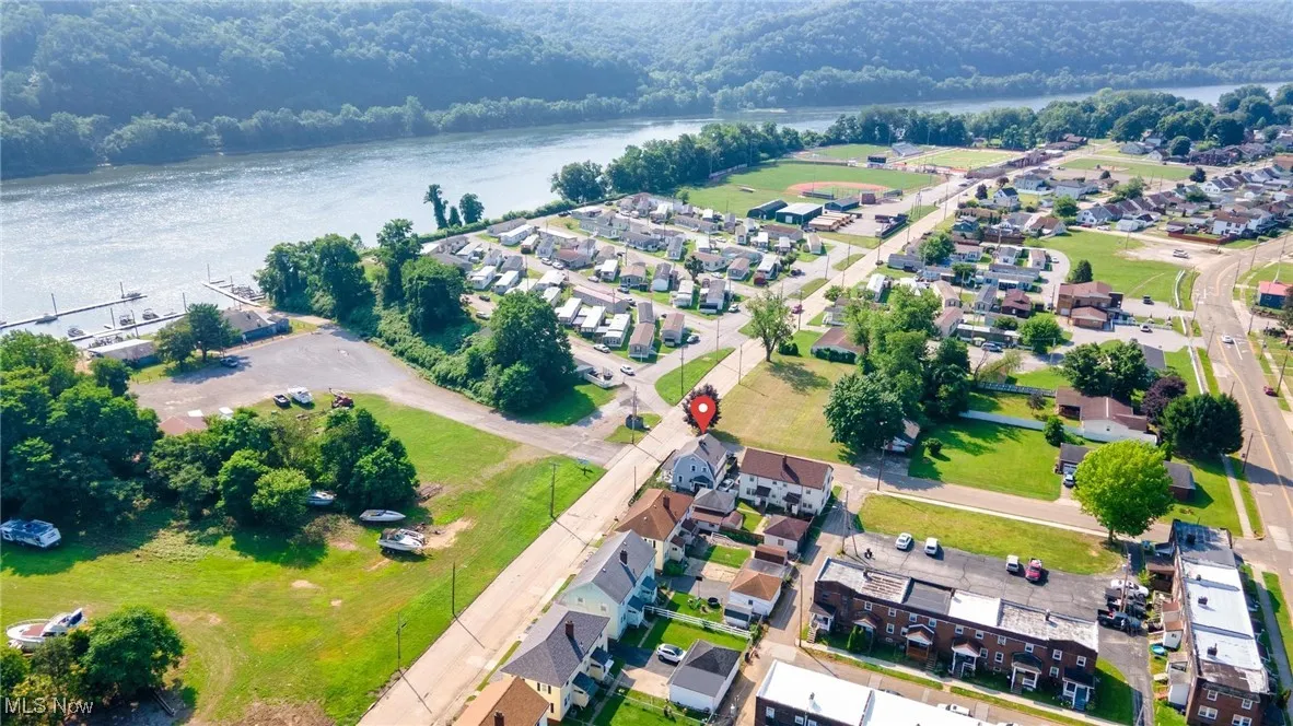 Aerial view of property and surrounding area with a large body of water and nearby suburban area