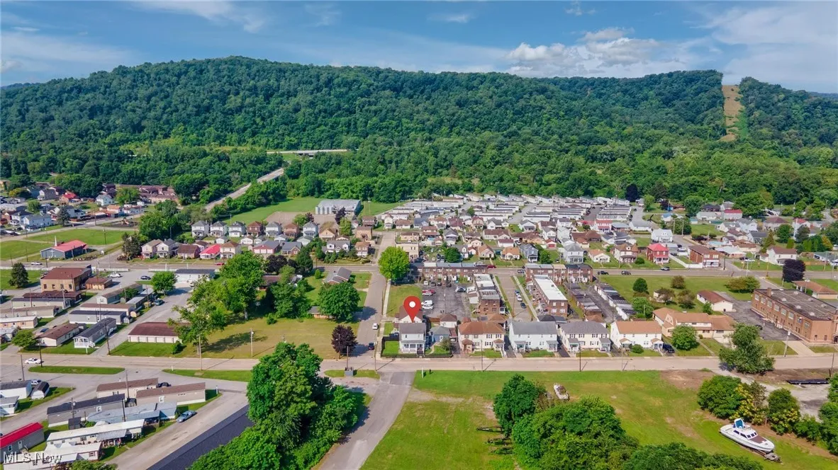 Aerial view of property's location featuring a forest and nearby suburban area