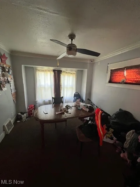 Home office featuring crown molding, a ceiling fan, and a textured ceiling