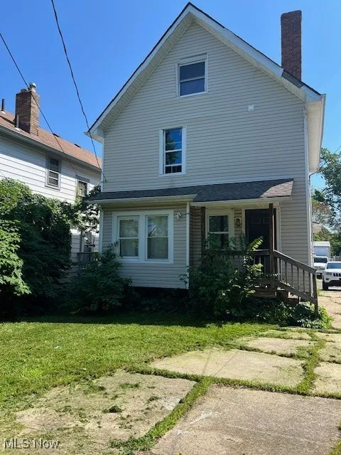 View of front facade with a front lawn and a chimney