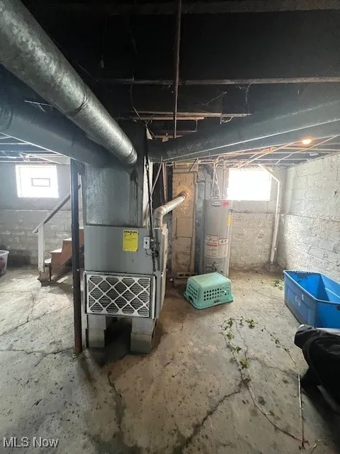 Below grade area featuring water heater and heating unit