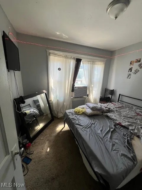 Bedroom with carpet flooring and cooling unit