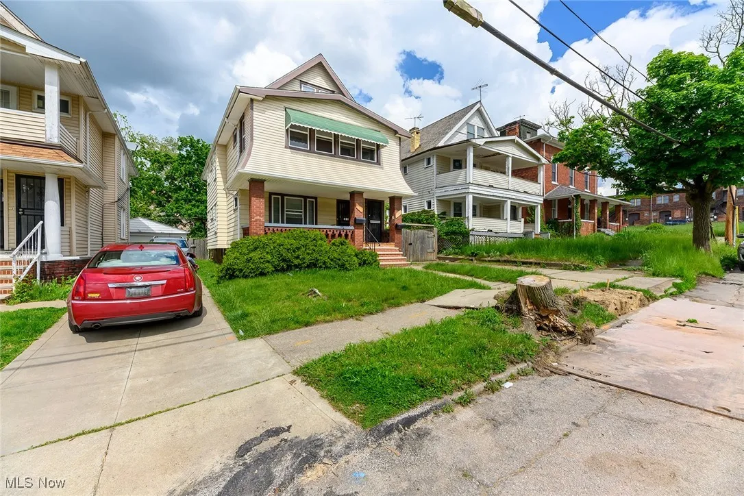 View of front of home featuring covered porch, driveway, and brick siding