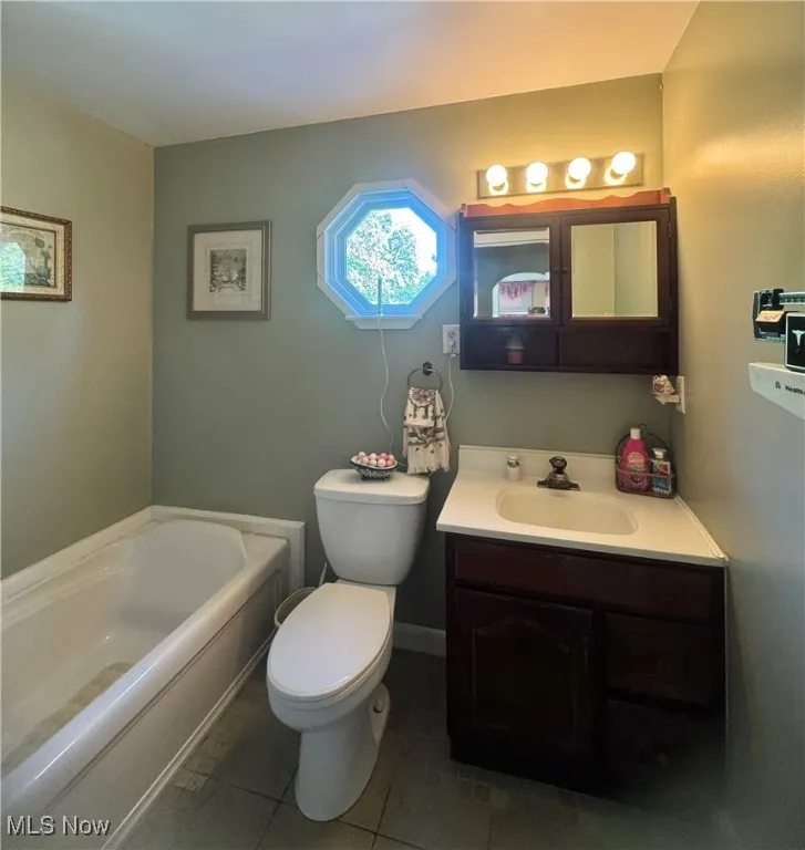 Full bathroom with a bath, vanity, and tile patterned floors