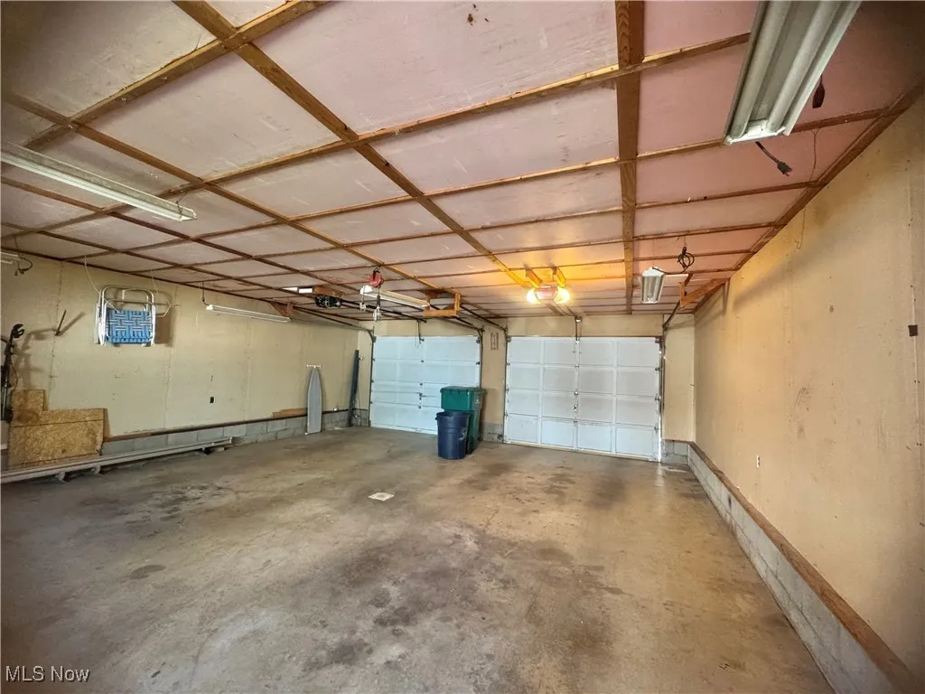 Garage featuring baseboards and a garage door opener