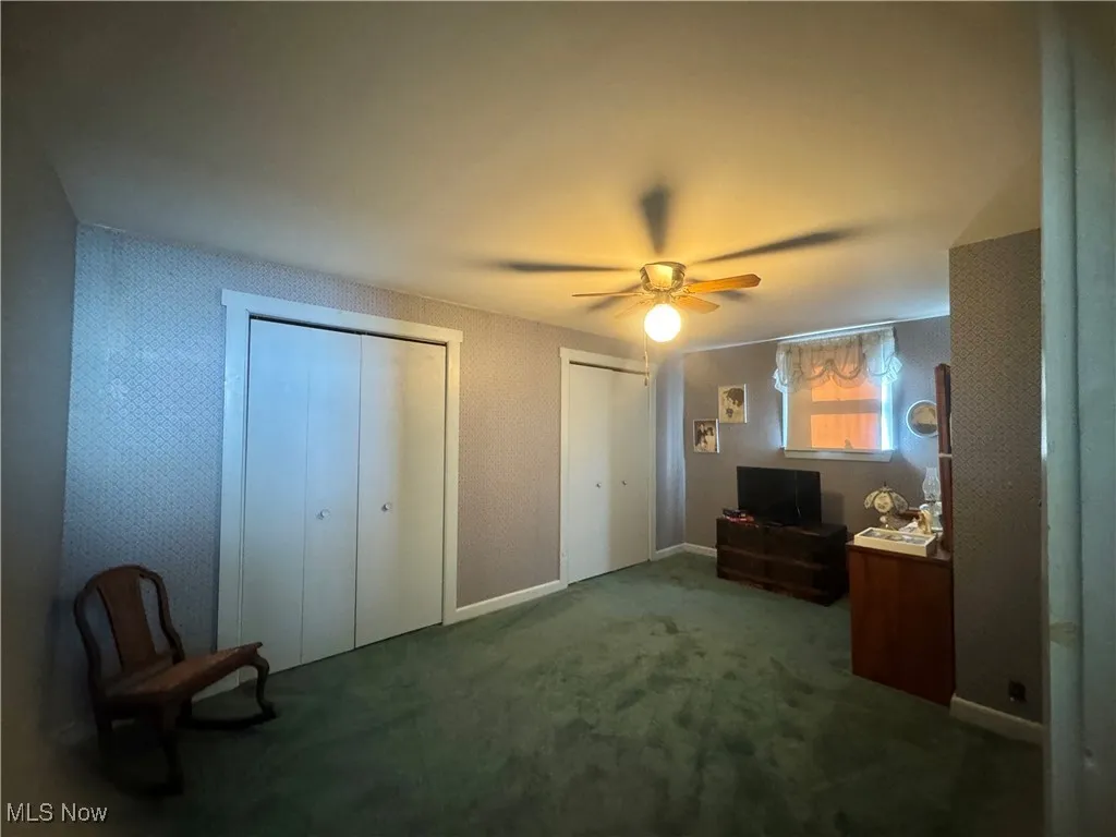 Unfurnished room with a ceiling fan and carpet flooring