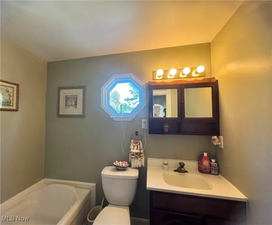 Bathroom featuring a garden tub and vanity