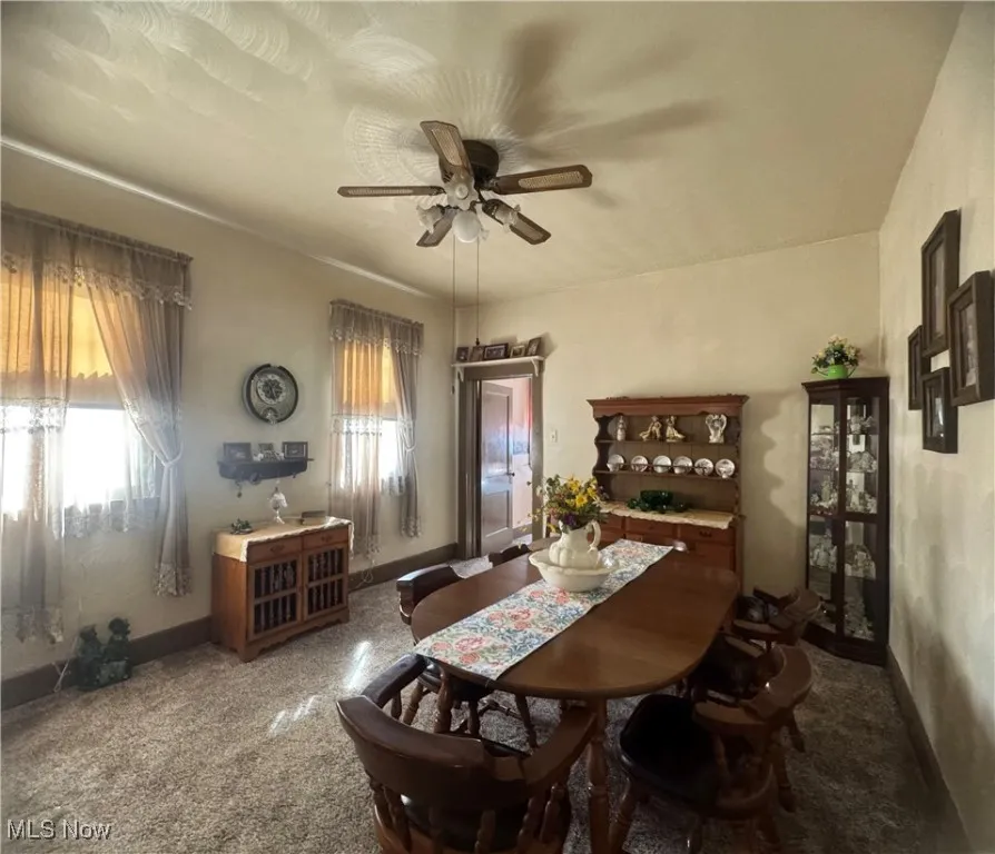 Dining room with a ceiling fan and baseboards