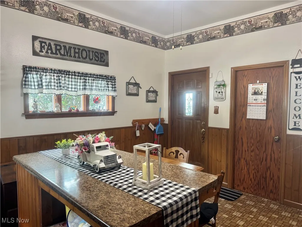 Dining room with a wainscoted wall and wooden walls
