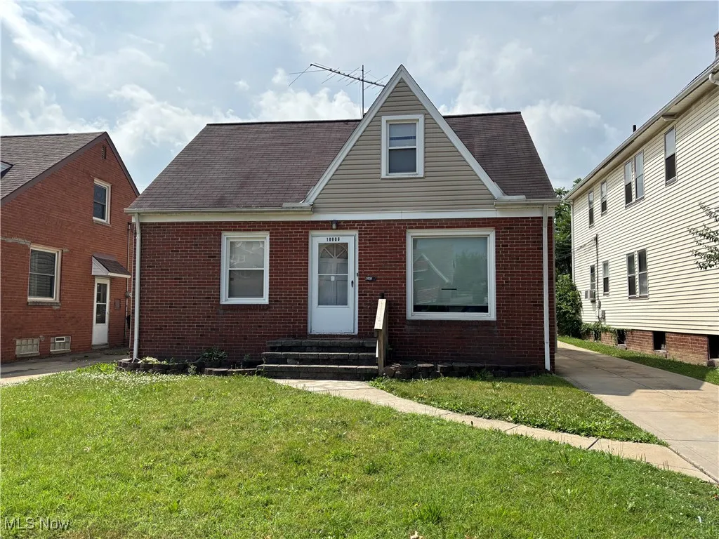 Bungalow featuring entry steps, brick siding, and a front yard