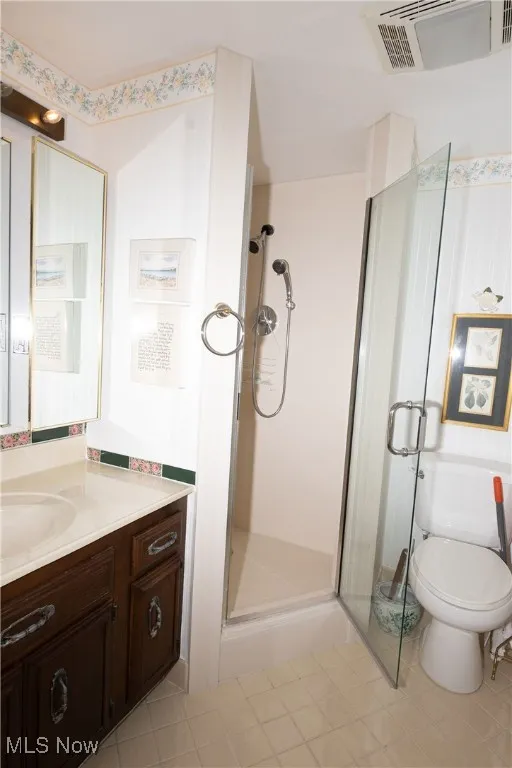 Bathroom with a stall shower, vanity, and tile patterned flooring