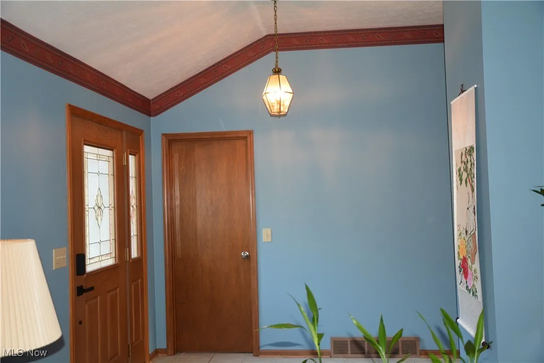 Entryway with a chandelier and lofted ceiling