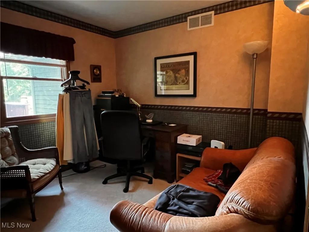 Office space featuring carpet floors, a wainscoted wall, and crown molding