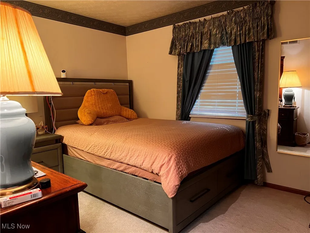 Carpeted bedroom featuring baseboards