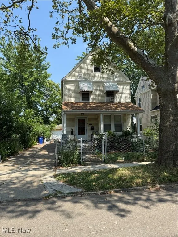 Victorian home featuring a porch, a gate, a fenced front yard, and driveway
