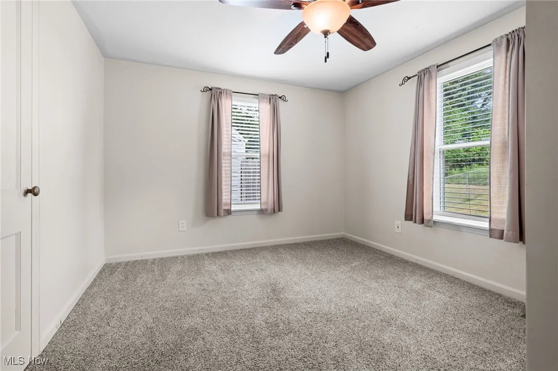 first floor Carpeted bedroom #2 featuring ceiling fan/light